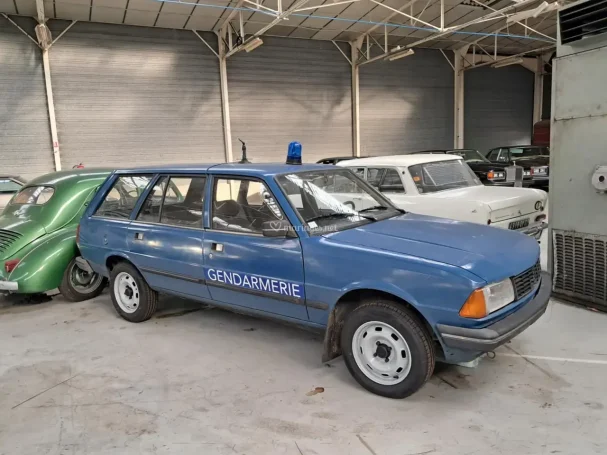 Voiture de police bleue, modèle station wagon, garée dans un musée automobile.